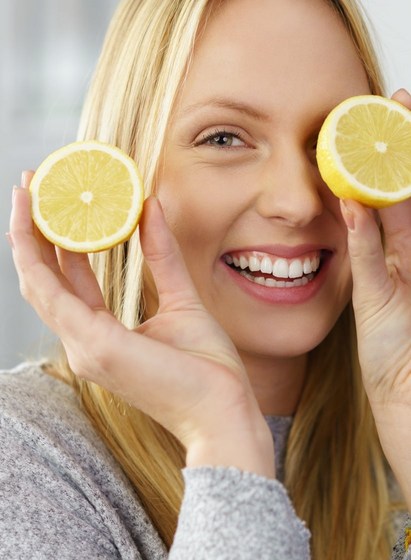Une femme souriante avec des citrons dans les mains